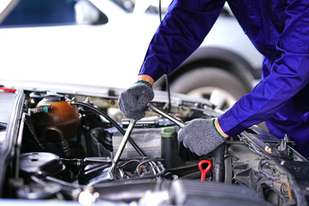 Auto mechanic using repair tools check car in Garage