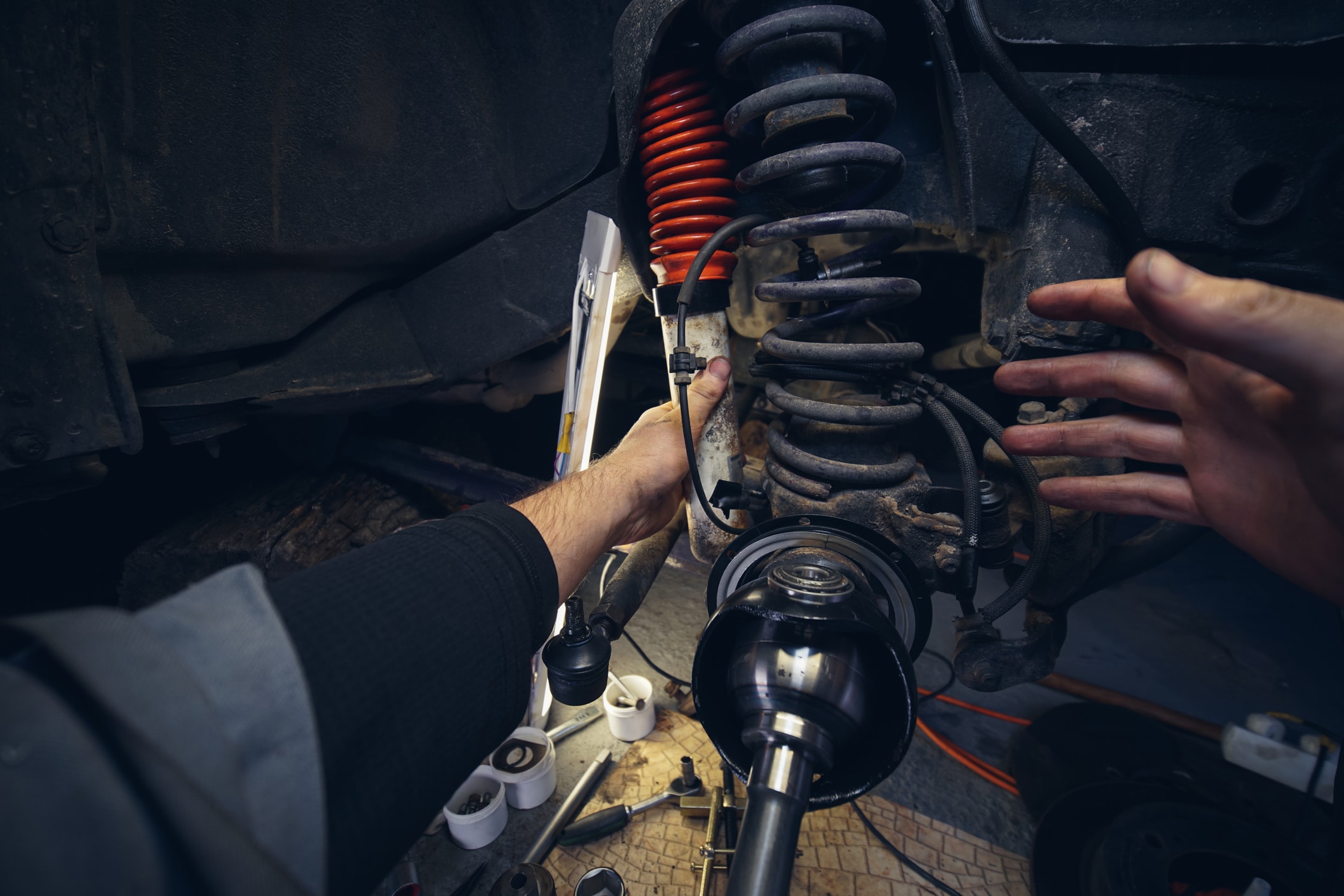 Car service from the first person mechanic. Male hands. Repair of the front wheel hub, replacement of Springs and shock absorber. four-wheel drive SUV.