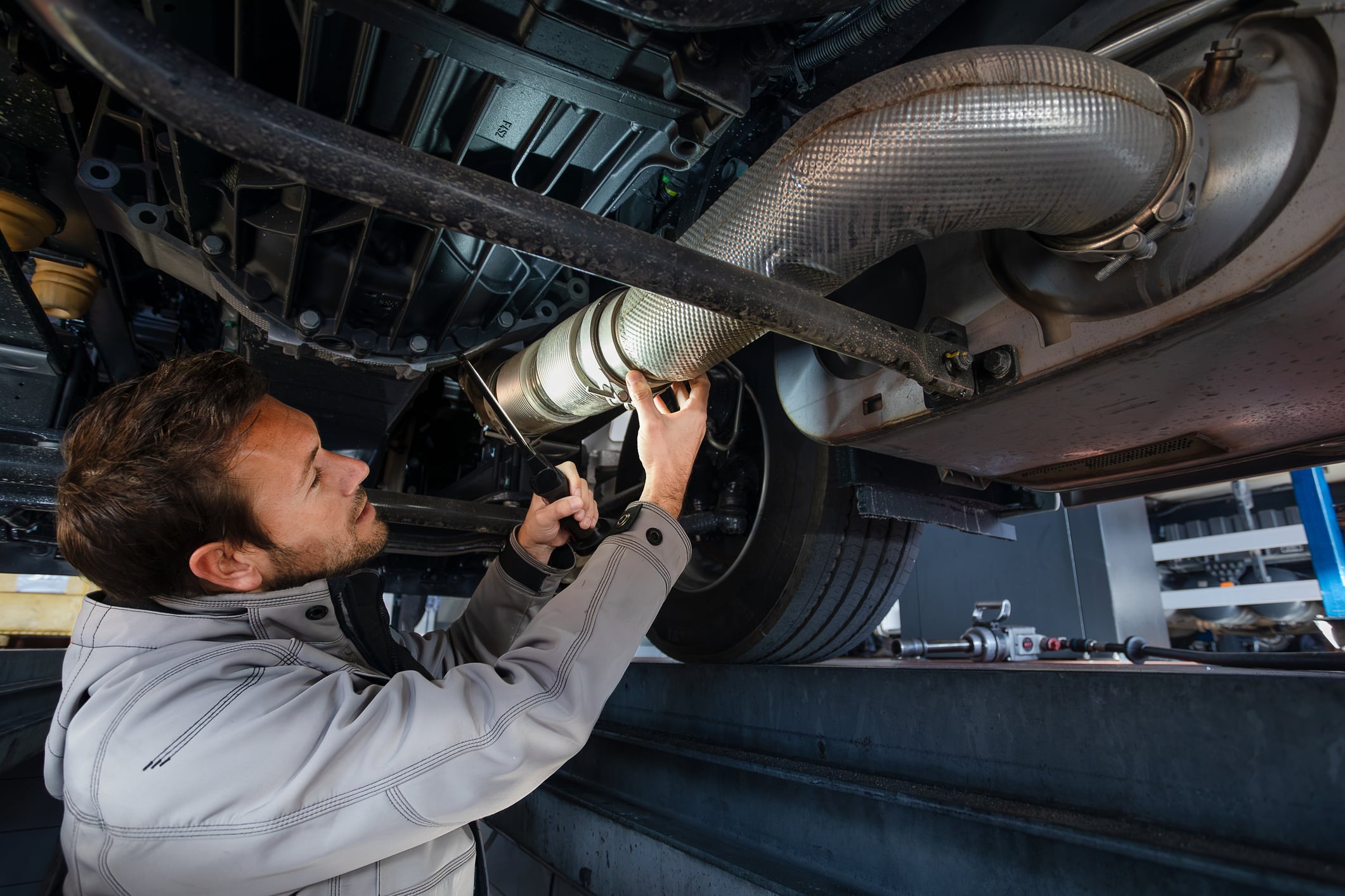 Truck mechanic checking exhaust pipe